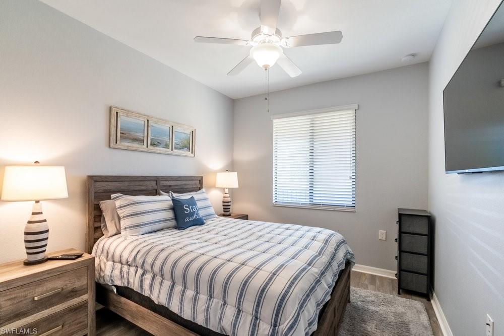 9578 Trevi Court, Unit 5142 Naples, FL 34113 - Photo 16 of 49 a bedroom with a bed and a flat screen tv