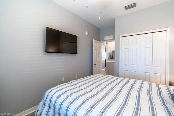 a bedroom with a bed and a flat screen tv