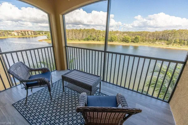 a balcony with wooden floor table and chairs