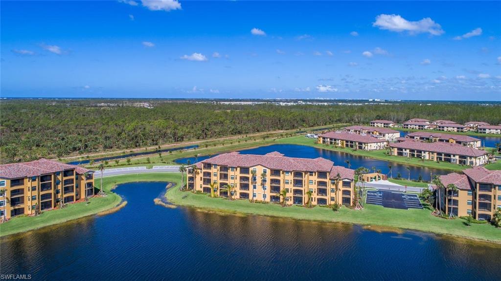 9578 Trevi Court, Unit 5142 Naples, FL 34113 - Photo 29 of 49 a view of a city with lawn chairs under an umbrella