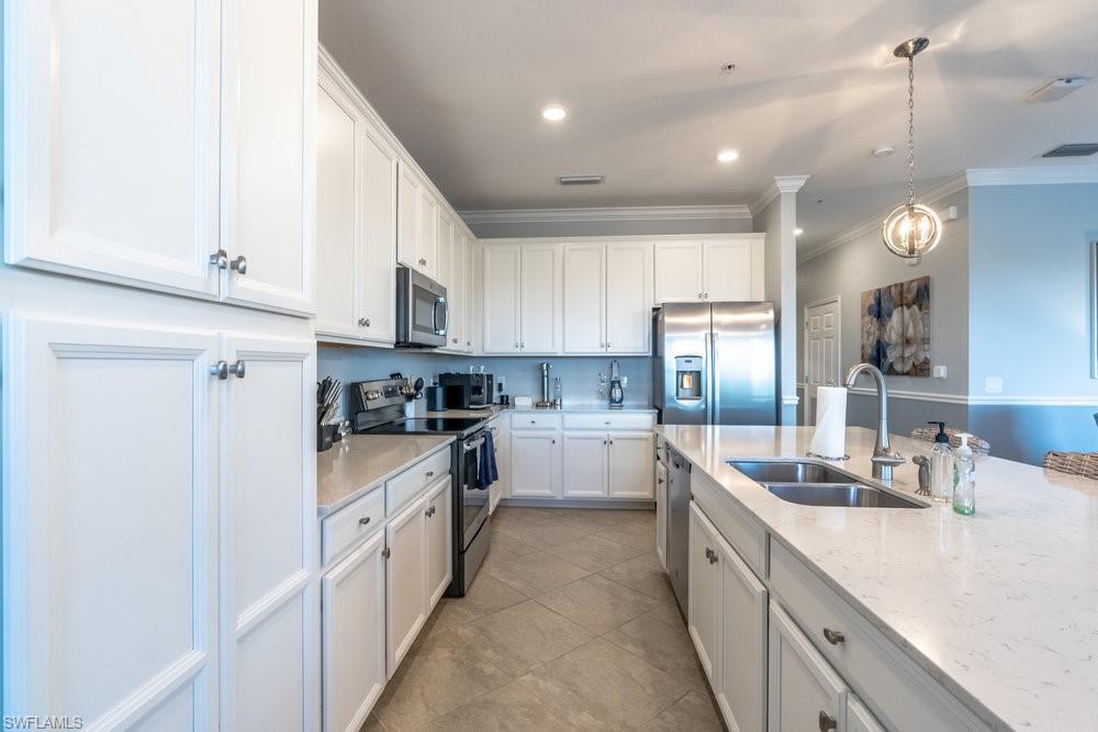 9578 Trevi Court, Unit 5142 Naples, FL 34113 - Photo 4 of 49 a kitchen with kitchen island granite countertop lots of white cabinets stainless steel appliances and a window