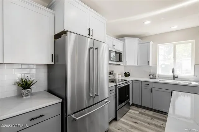 a kitchen with stainless steel appliances a sink cabinets and a refrigerator