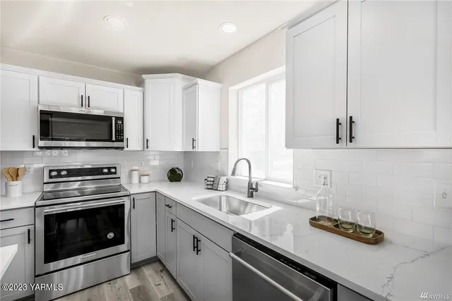 a kitchen with appliances a sink and cabinets