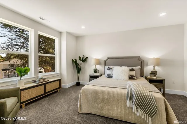 a bedroom with a bed and a large window with outer view