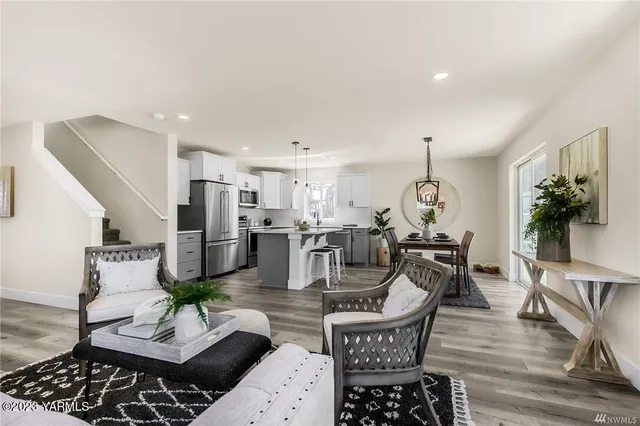 a living room with lots of furniture and kitchen view