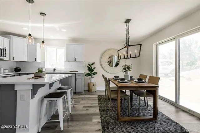 a view of a dining room and livingroom with furniture wooden floor a chandelier