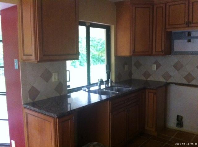 2298 Northwest 35th Street Boca Raton, FL 33431 - Photo 6 of 26 a kitchen with granite countertop a sink a window and cabinets