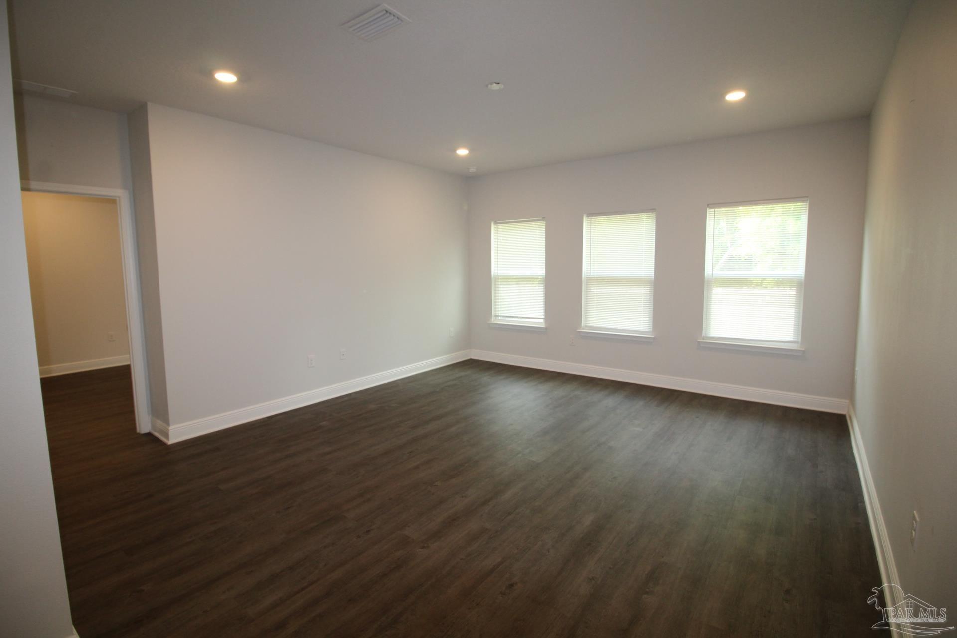 8006 Burnside Loop Pensacola, FL 32526 - Photo 7 of 22 an empty room with wooden floor and windows