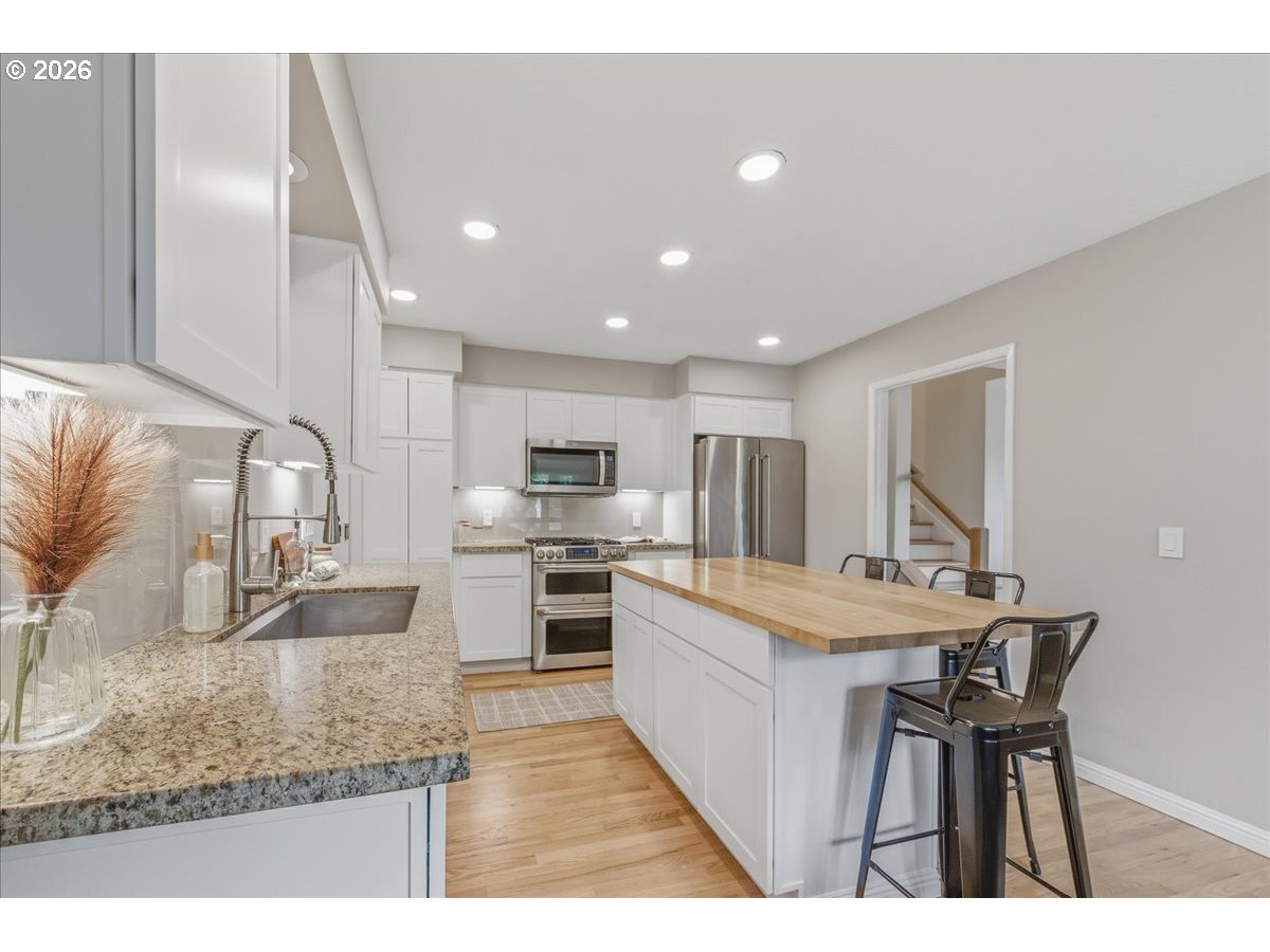 3130 Southwest 116th Avenue Beaverton, OR 97005 - Photo 14 of 44 a kitchen with stainless steel appliances granite countertop a sink stove and refrigerator