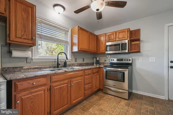 a kitchen with stainless steel appliances granite countertop a sink and a stove