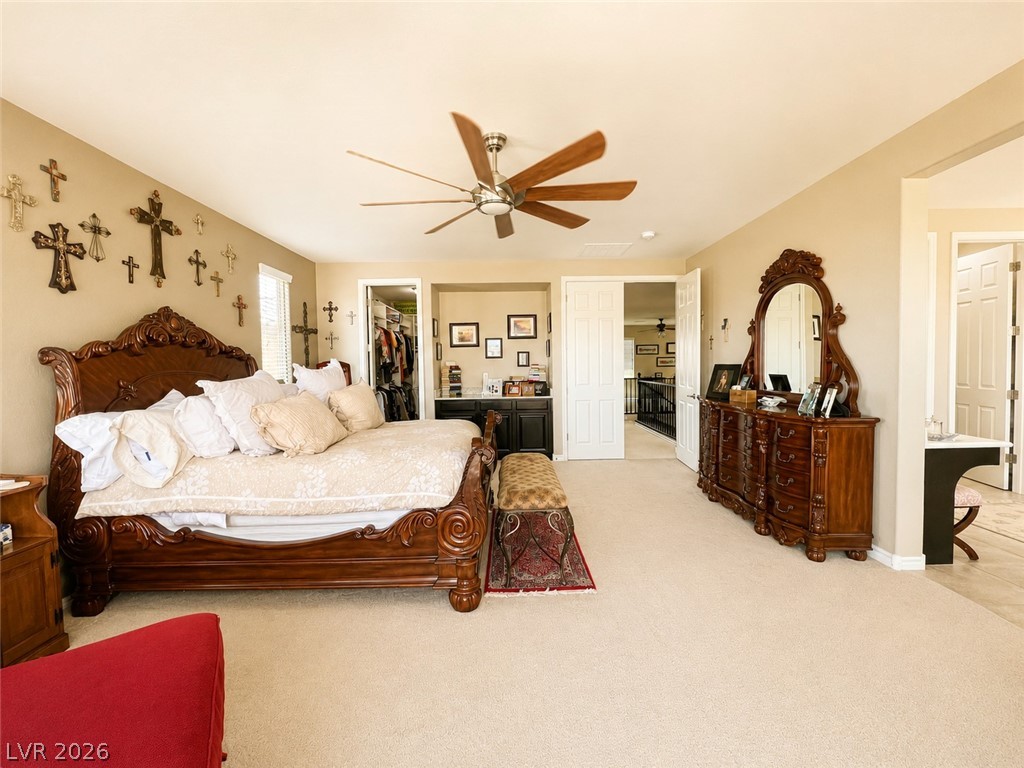 9724 University Ridge Avenue Las Vegas, NV 89149 - Photo 50 of 61 Relax in a generously sized primary bedroom featuring a ceiling fan for comfort and carpeted flooring underfoot.