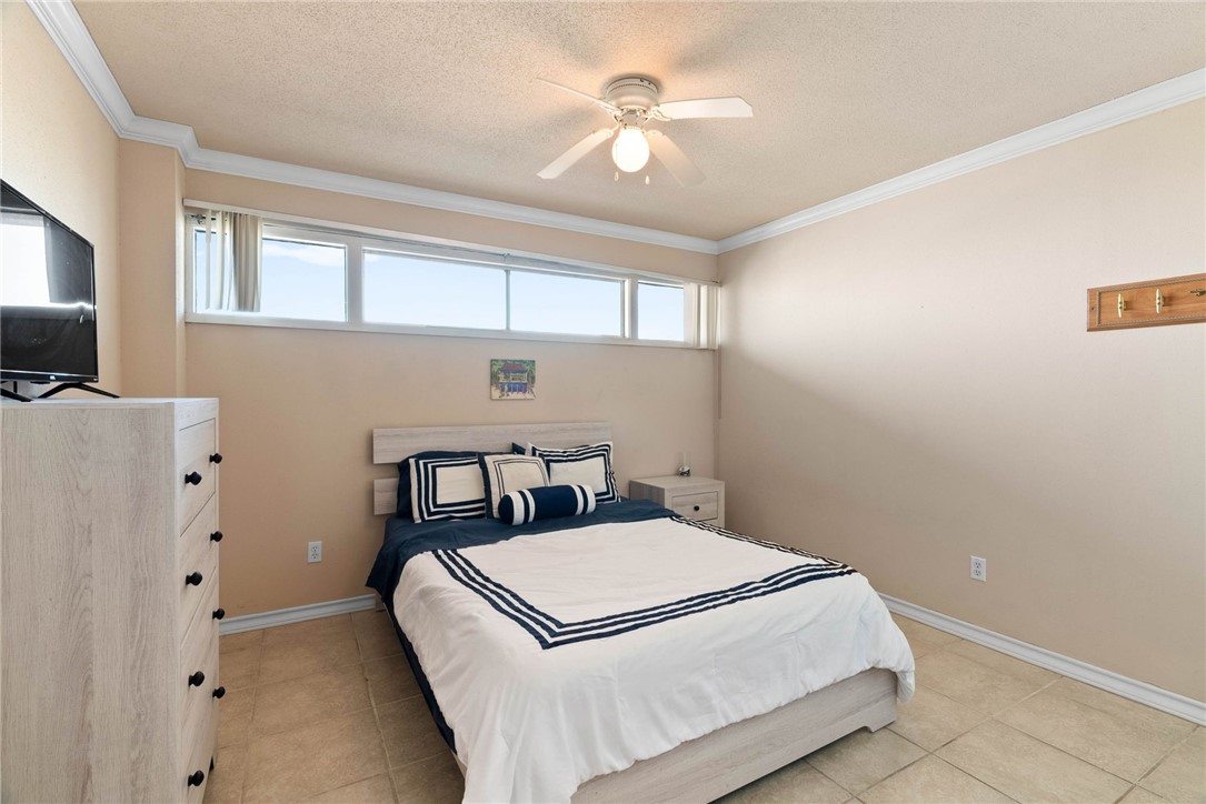 4000 Surfside Boulevard, Unit 508 Corpus Christi, TX 78402 - Photo 15 of 32 a bedroom with a bed and a chandelier