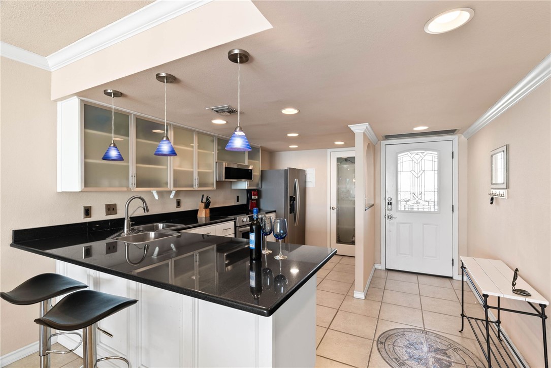 4000 Surfside Boulevard, Unit 508 Corpus Christi, TX 78402 - Photo 2 of 32 a kitchen with granite countertop a sink and cabinets