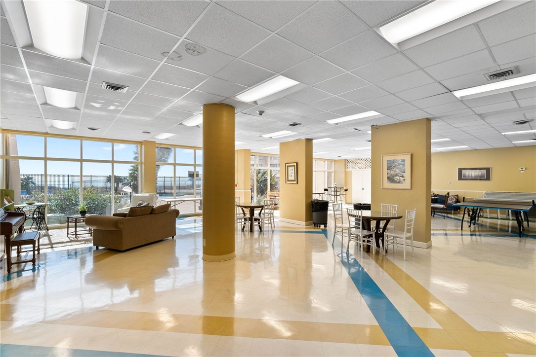 4000 Surfside Boulevard, Unit 508 Corpus Christi, TX 78402 - Photo 21 of 32 a living room with furniture and a dining table with wooden floor