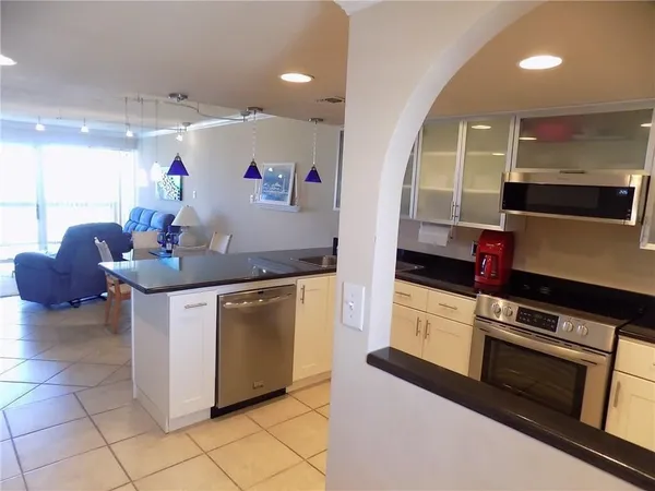 a kitchen with stainless steel appliances granite countertop a stove a sink and a microwave