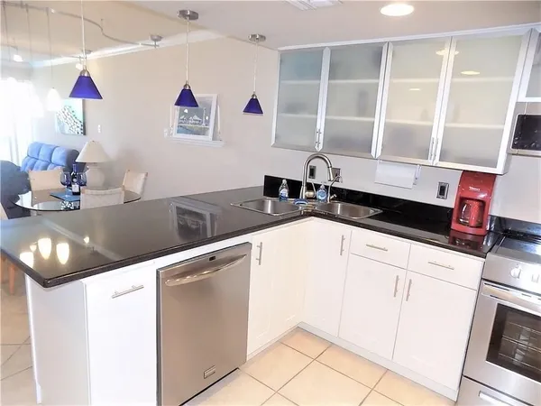 a kitchen with granite countertop a sink a stove and cabinets