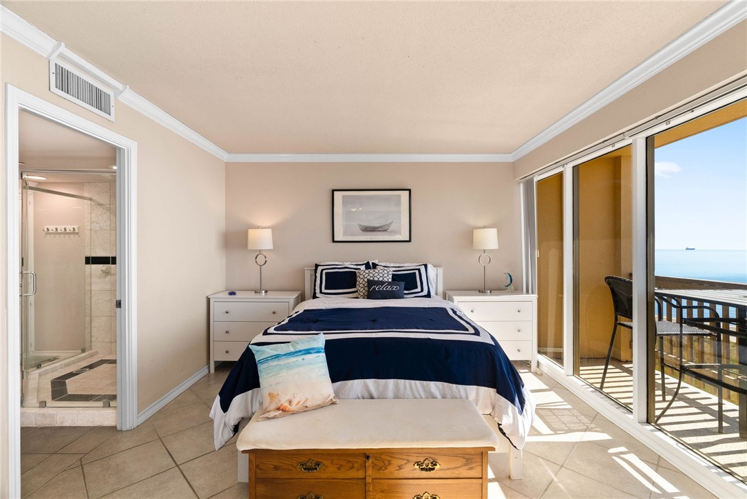 4000 Surfside Boulevard, Unit 508 Corpus Christi, TX 78402 - Photo 9 of 32 a bedroom with a bed and glass door