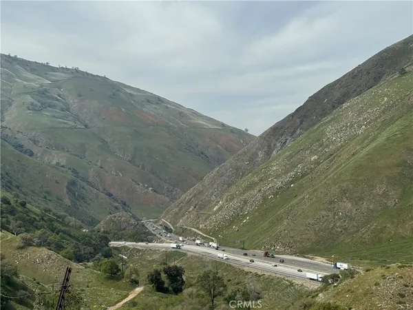 a view of a dry yard with mountains in the background