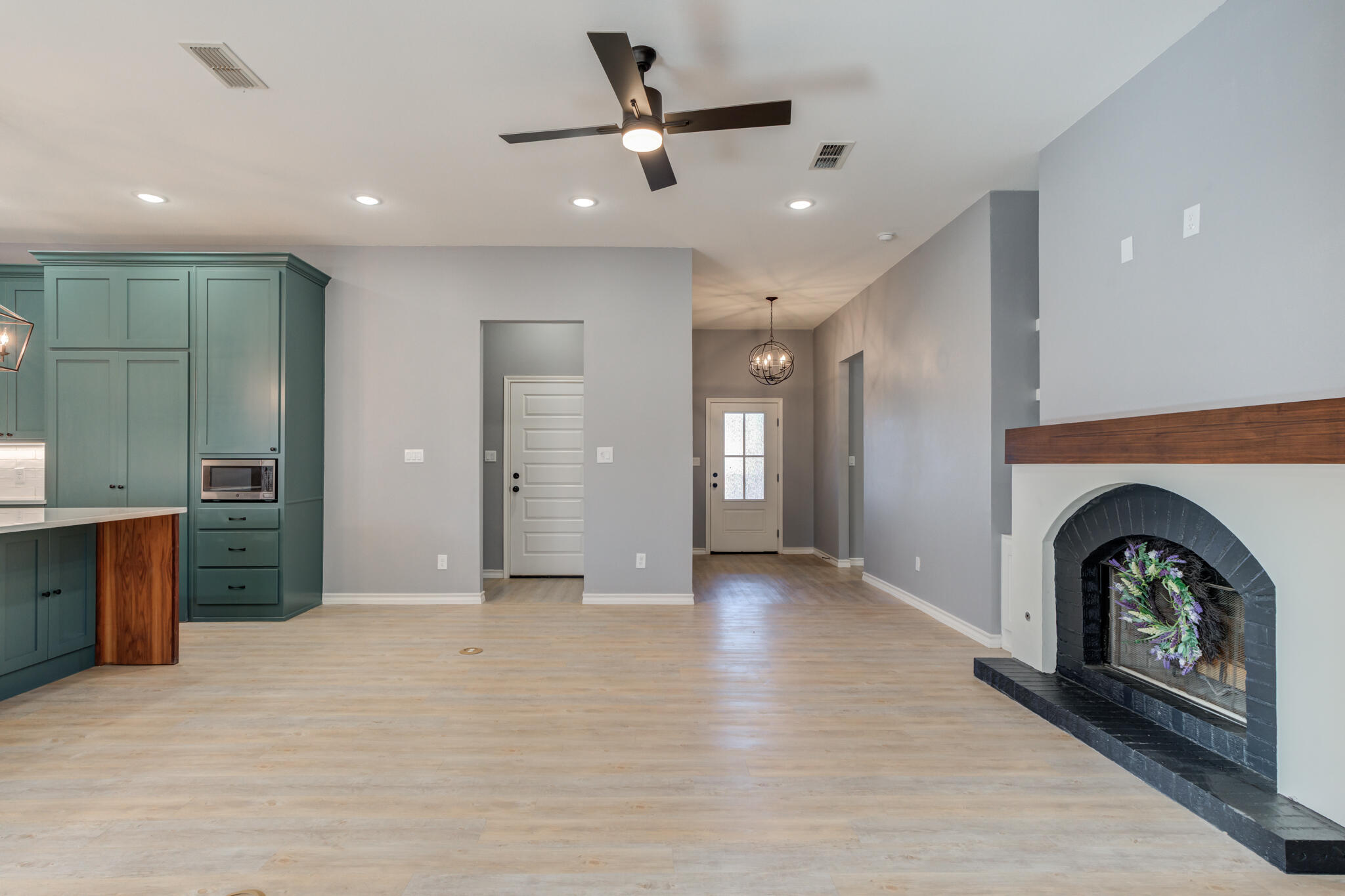12701 Kenosha Avenue Lubbock, TX 79423 - Photo 13 of 61 a view of a livingroom with a fireplace a ceiling fan and wooden floor