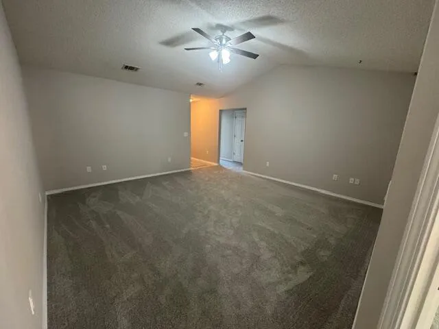 an empty room with a ceiling fan and a window