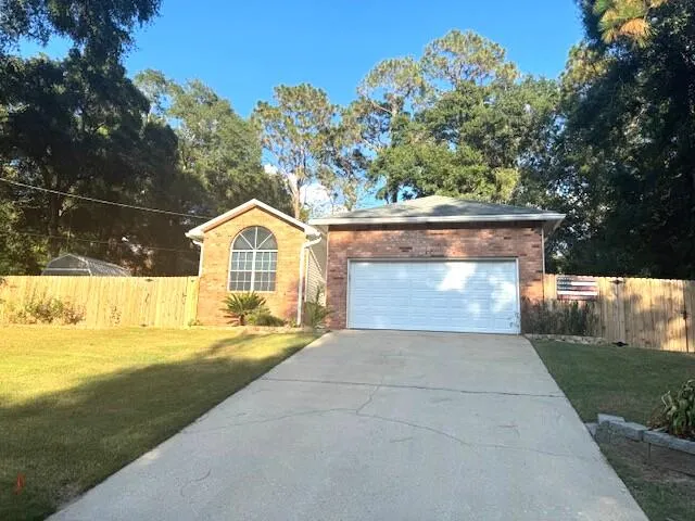 a view of a house with a yard and a large tree