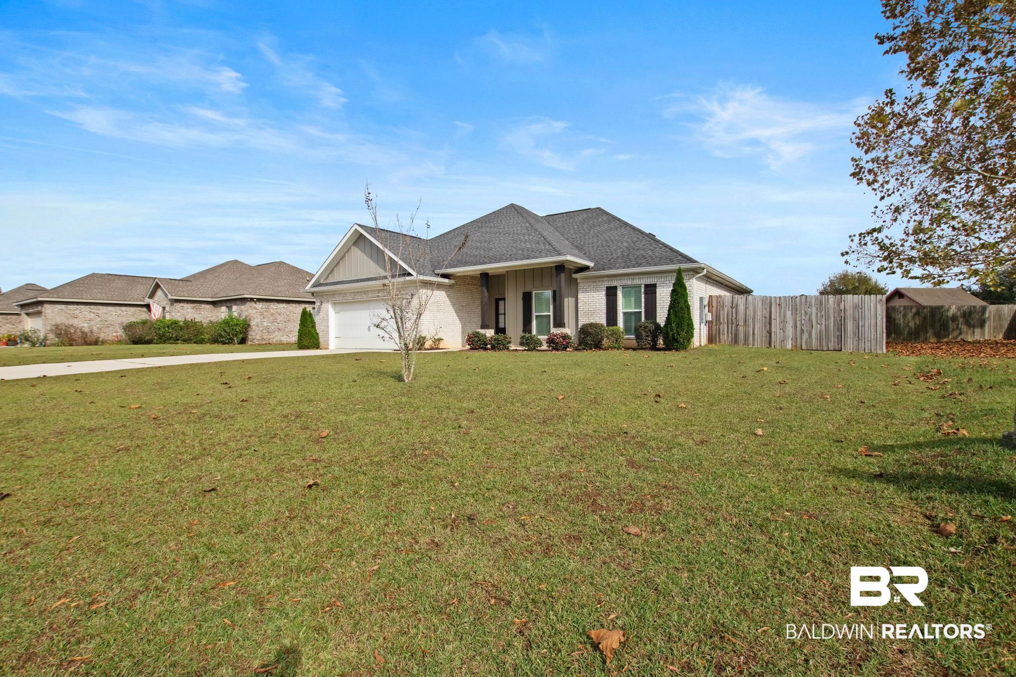 17376 Bankhead Boulevard Fairhope, AL 36532 - Photo 5 of 73 Ranch-style home featuring a garage, driveway, brick siding, and board and batten siding