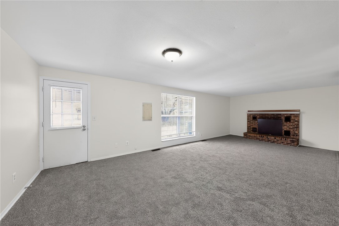 6070 Charlesgate Road Huber Heights, OH 45424 - Photo 12 of 29 This expansive room offers a blank canvas for personalized living, featuring a charming brick fireplace.