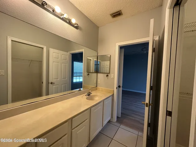 a spacious bathroom with a double vanity sink a large mirror and a shower
