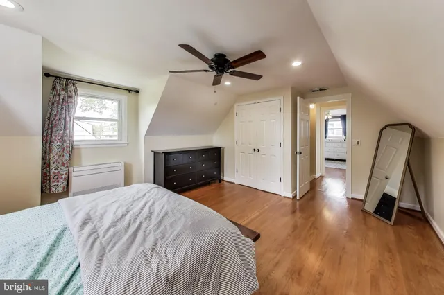 a view of a livingroom with a fireplace a ceiling fan and wooden floor