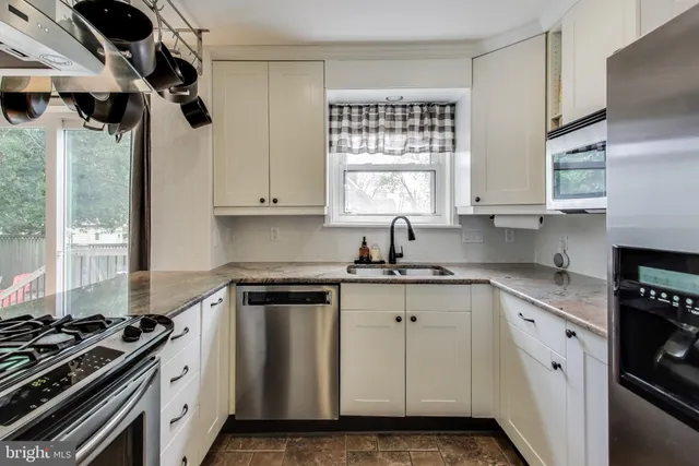 a kitchen with stainless steel appliances a stove a sink and a cabinets