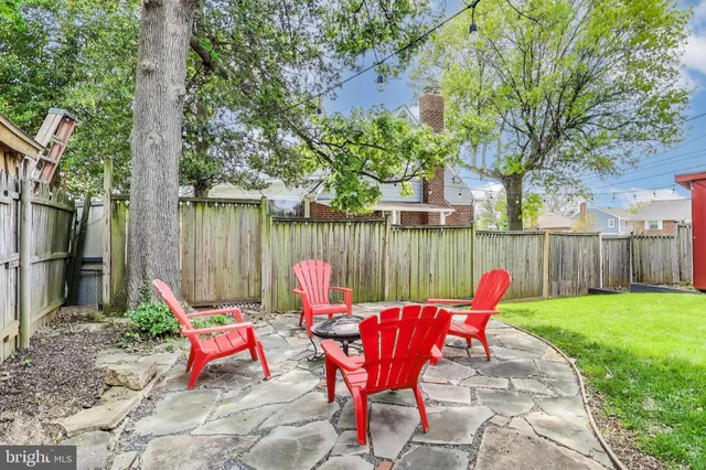 a backyard view of a house with seating space and wooden fence