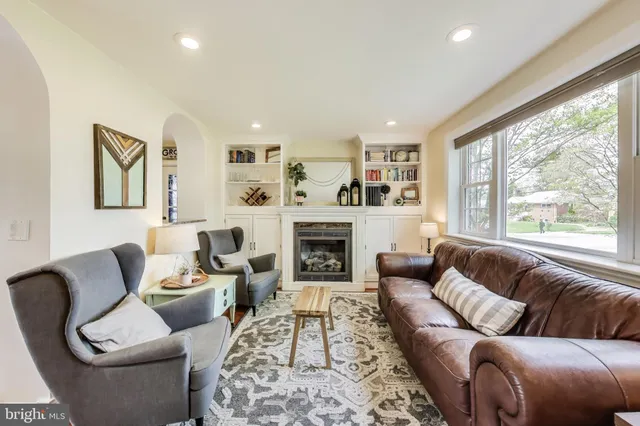 a living room with furniture large window and fireplace