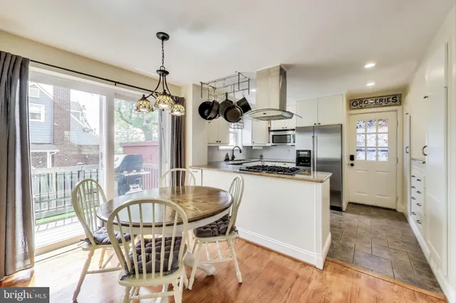 a kitchen with a table chairs refrigerator and cabinets
