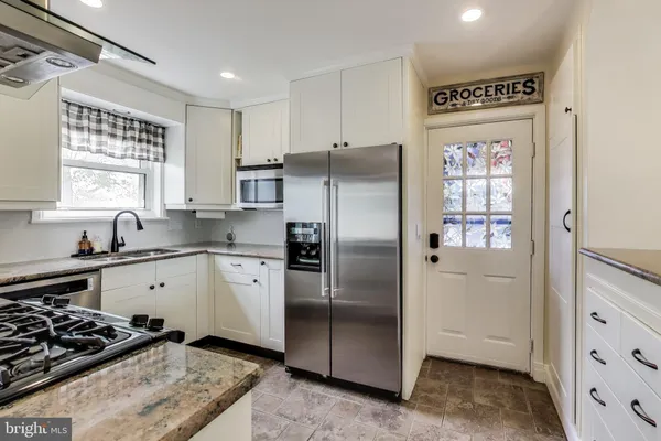 a kitchen with a refrigerator sink and cabinets
