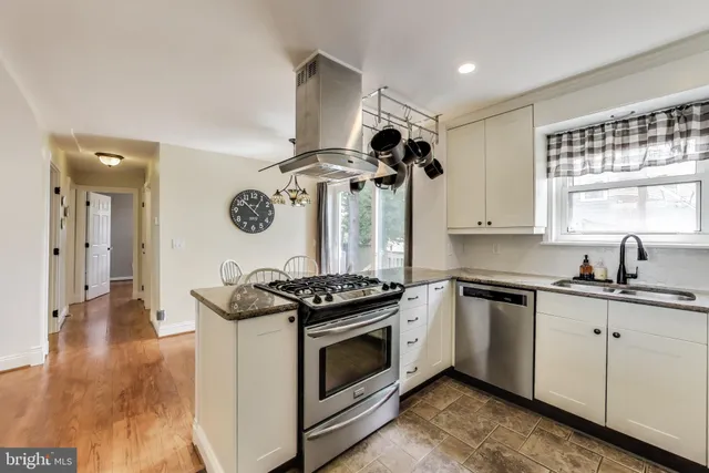 a kitchen with stainless steel appliances granite countertop a stove and a sink