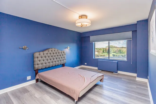 a bedroom with a bed and a lamp with wooden floor