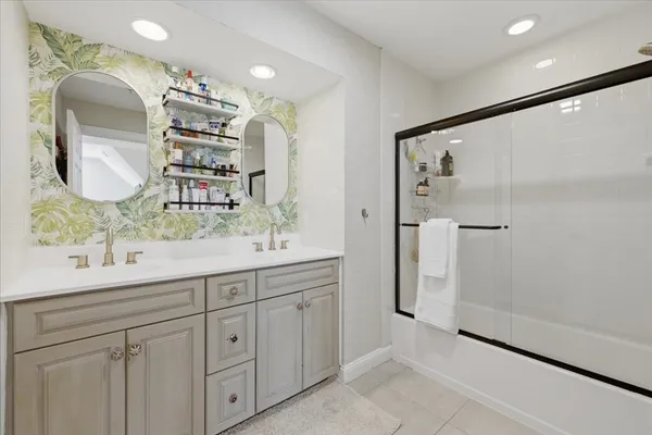 a bathroom with a double vanity sink mirror and shower