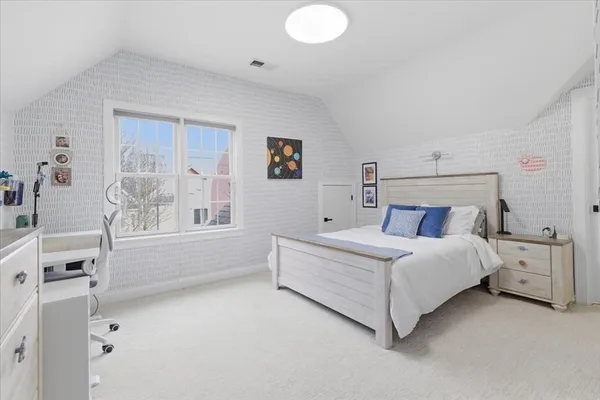 a spacious bedroom with a bed and a window