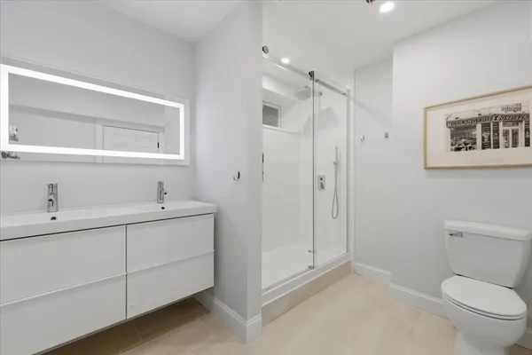 a bathroom with a toilet sink and mirror