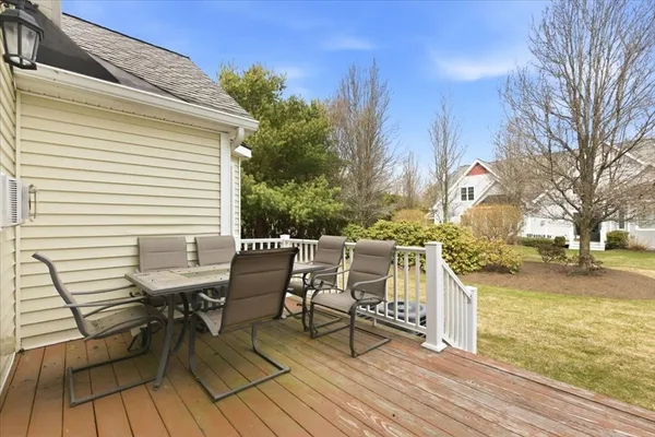 a view of a patio with table and chairs with wooden floor and fence