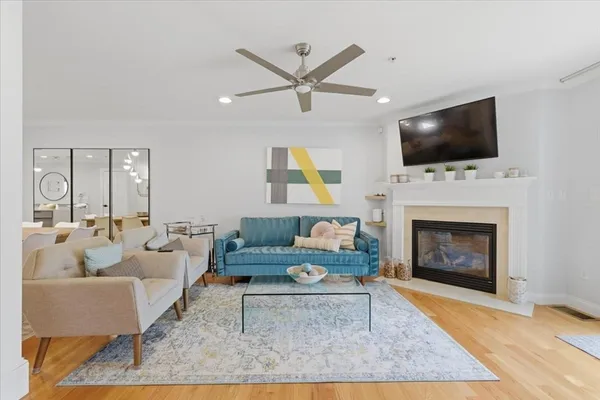 a living room with furniture a flat screen tv and a fireplace