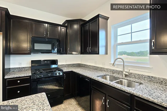 a kitchen with kitchen island stainless steel appliances a refrigerator a stove top oven and a sink