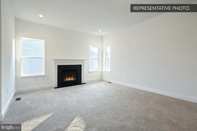 a large white kitchen with stainless steel appliances kitchen island a stove a refrigerator a oven and a sink