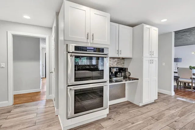 a kitchen with white cabinets and stainless steel appliances