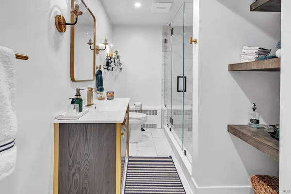 a bathroom with a sink a toilet and shower
