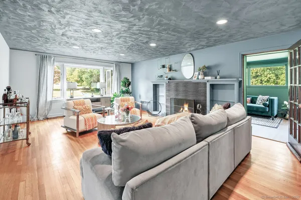 a living room with furniture fireplace and a large window