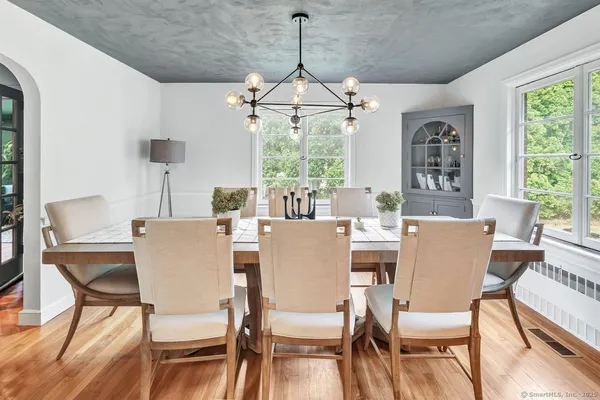 a dining room with furniture a chandelier and window