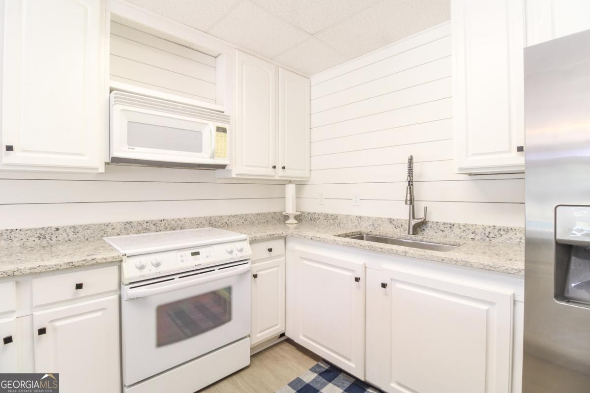 1380 Sunset Ridge Watkinsville, GA 30677 - Photo 36 of 74 a kitchen with granite countertop white cabinets and white appliances