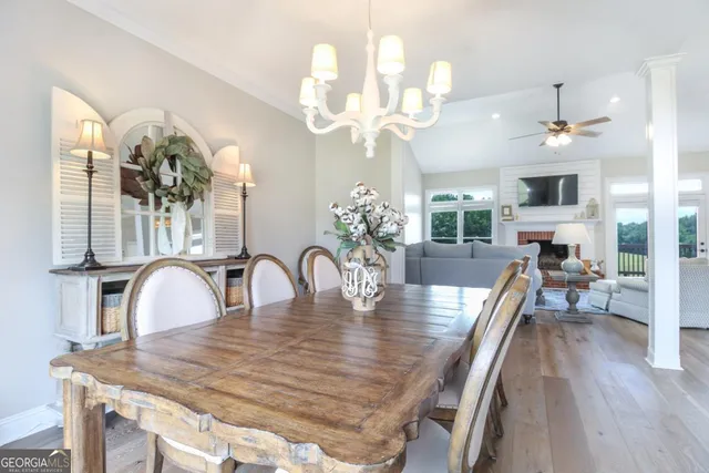a dining room with wooden floor a chandelier a wooden table and chairs
