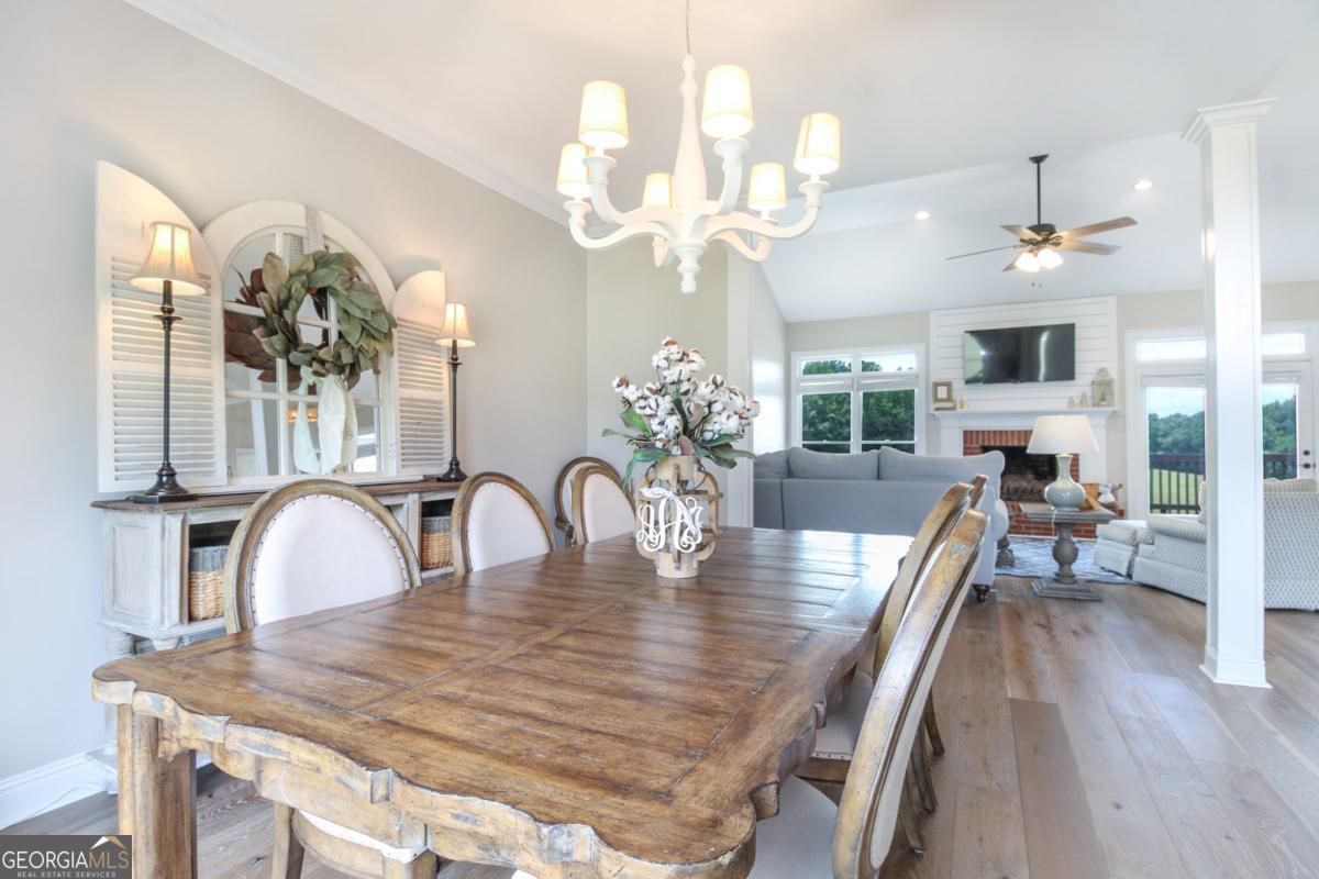 1380 Sunset Ridge Watkinsville, GA 30677 - Photo 8 of 74 a dining room with wooden floor a chandelier a wooden table and chairs